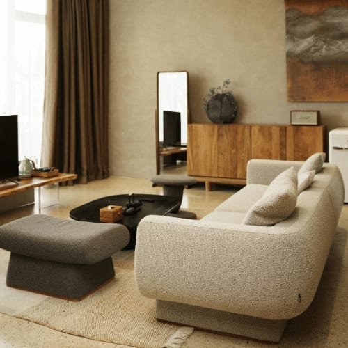 A quiet living room with a pale sofa, a low table and wooden shelves